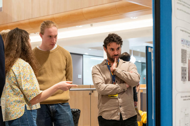 Guillaume MacNeil (Research Associate) and colleagues discussing academic posters discussing academic posters at the 5th birthday symposium held by Oxford's Kavli Institute for Nanoscience Discovery (Kavli INsD) 