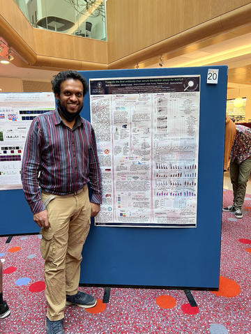 A photograph of Bevin Gangadharan with his poster.