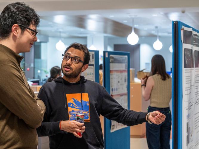 Dr Saurabh Talele and Zile Zhuang (Doctoral Student) discussing academic posters at the 5th birthday symposium held by Oxford's Kavli Institute for Nanoscience Discovery (Kavli INsD)
