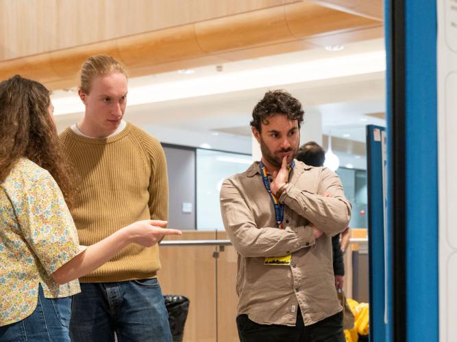 Guillaume MacNeil (Research Associate) and colleagues discussing academic posters discussing academic posters at the 5th birthday symposium held by Oxford's Kavli Institute for Nanoscience Discovery (Kavli INsD) 