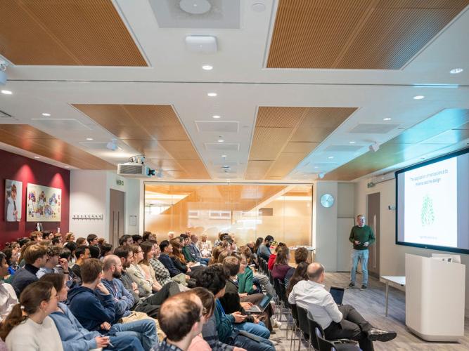 Seated delegates listen to Professor Matt Higgins giving the keynote lecture, titled 'The application of nanoscience to malaria vaccine design', at the 5th birthday symposium held by Oxford's Kavli Institute for Nanoscience Discovery.