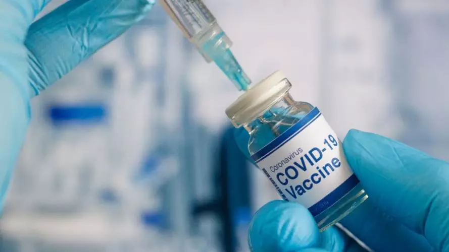 close up shot of a covid vaccine and a syringe